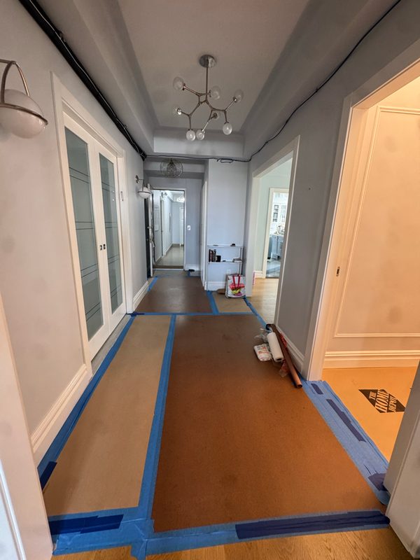 Long apartment hallway with protective floor covering taped down along its length