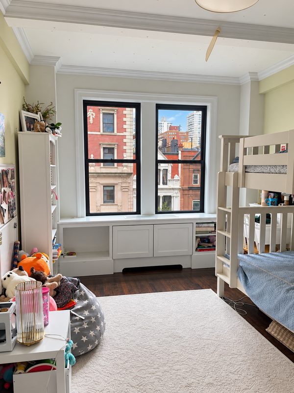 Bedroom with two new black framed double hung windows above a window seat, and a bunk bed