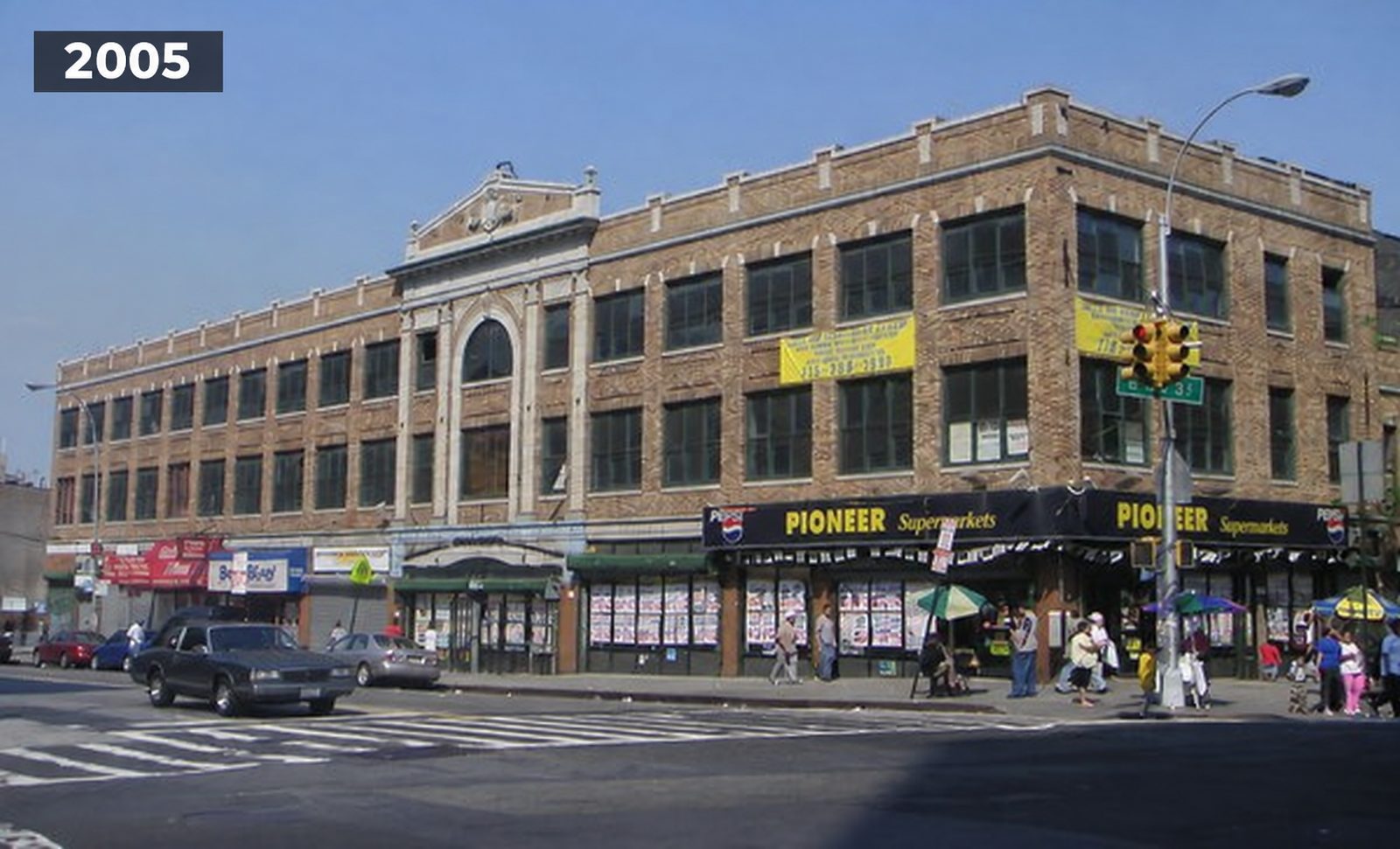 The building seen from the street corner in 2005, a three story brick building with a supermarket at street level