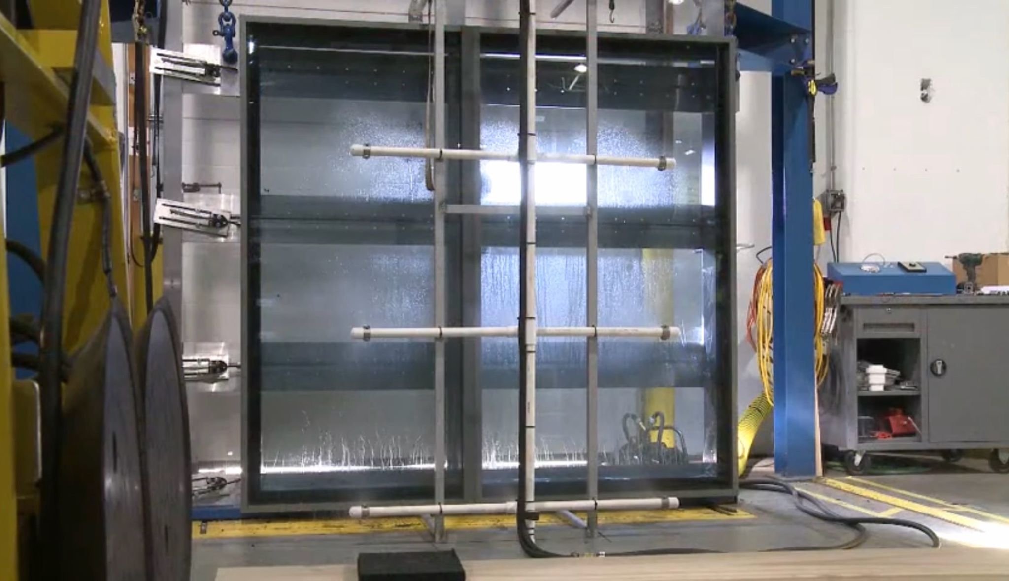 Window specimen mounted in a water penetration test chamber in a manufacturing plant